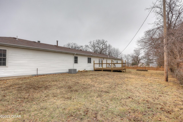 back of house with central AC unit, a deck, and a lawn