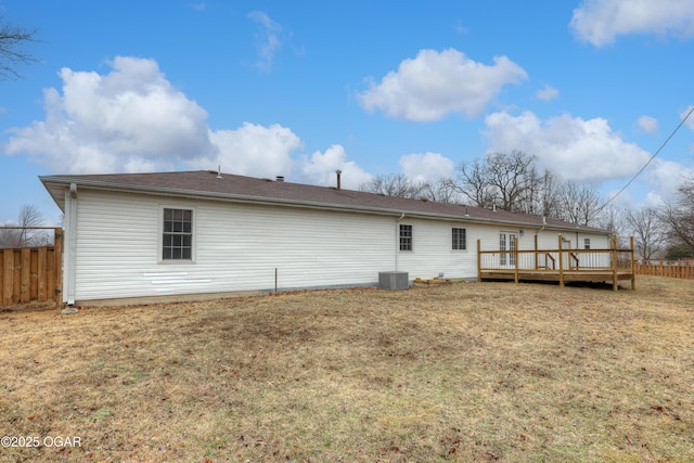 rear view of house with central AC, a lawn, and a deck