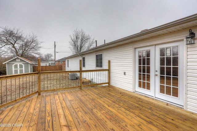 wooden terrace featuring central AC unit, french doors, and a storage unit