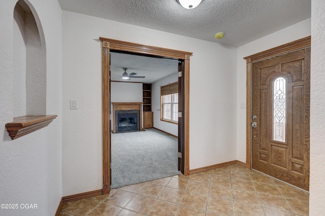 entryway with a textured ceiling and light tile patterned flooring