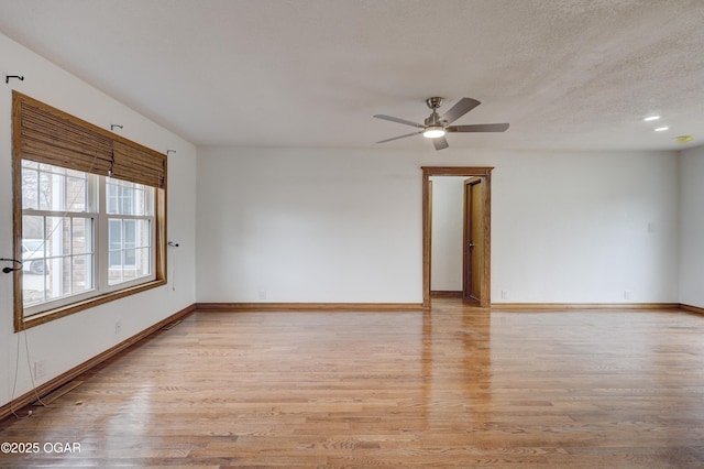 unfurnished room with ceiling fan, a textured ceiling, and light hardwood / wood-style flooring