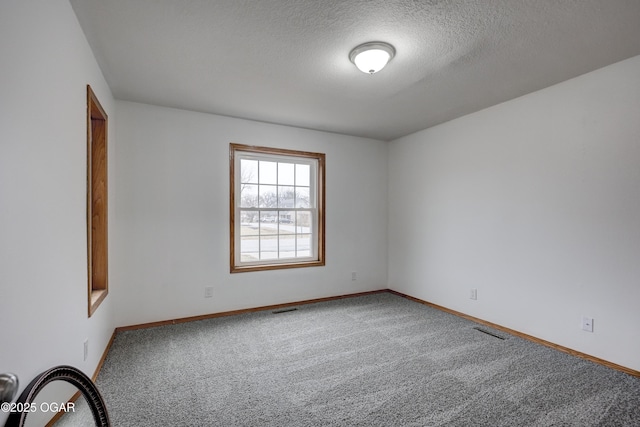 carpeted spare room with a textured ceiling