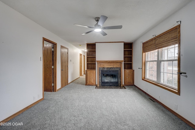 unfurnished living room with ceiling fan, light colored carpet, and a fireplace