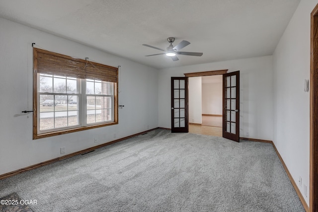 carpeted spare room with french doors and ceiling fan