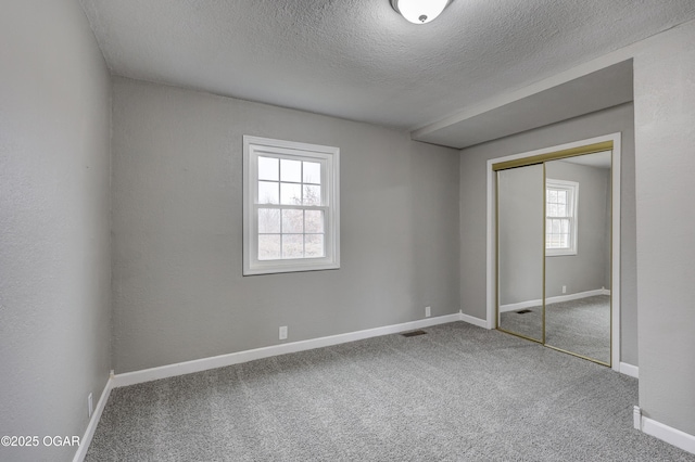 unfurnished bedroom with a closet, carpet, and a textured ceiling