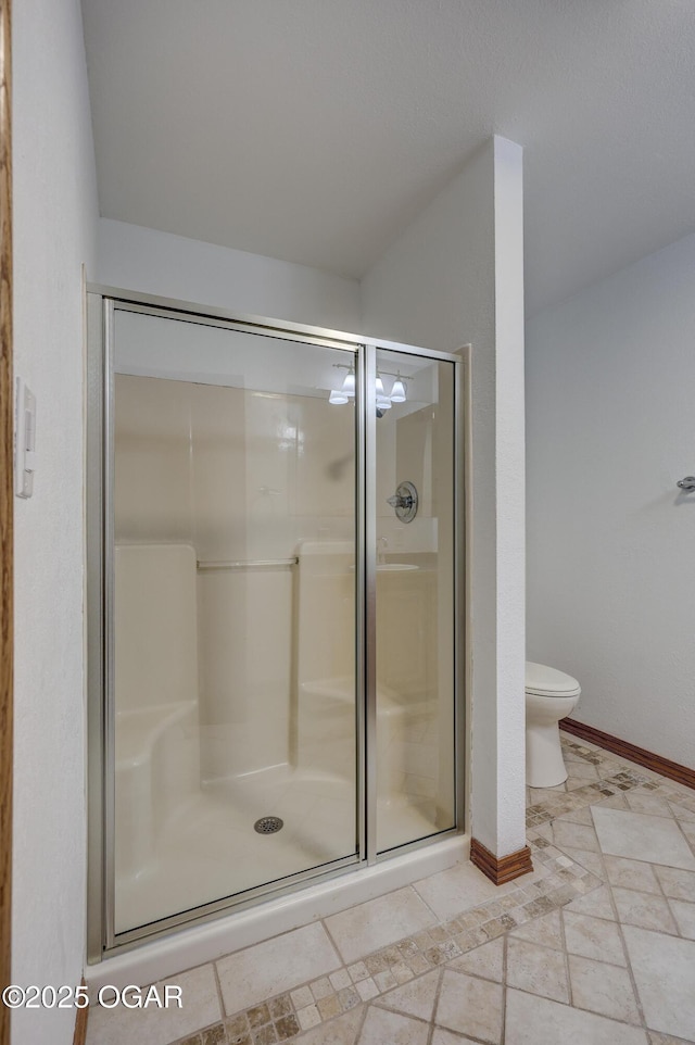 bathroom with a shower with door and toilet