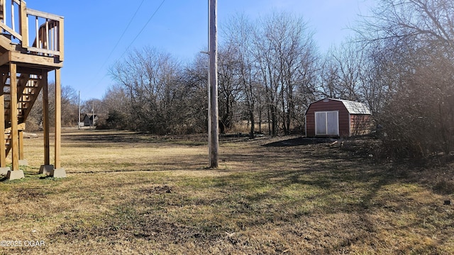 view of yard featuring a wooden deck and a storage unit