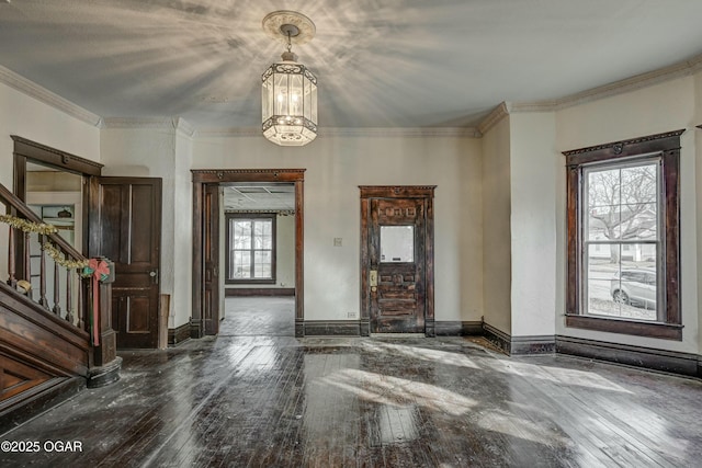 entrance foyer with a notable chandelier, wood-type flooring, and ornamental molding