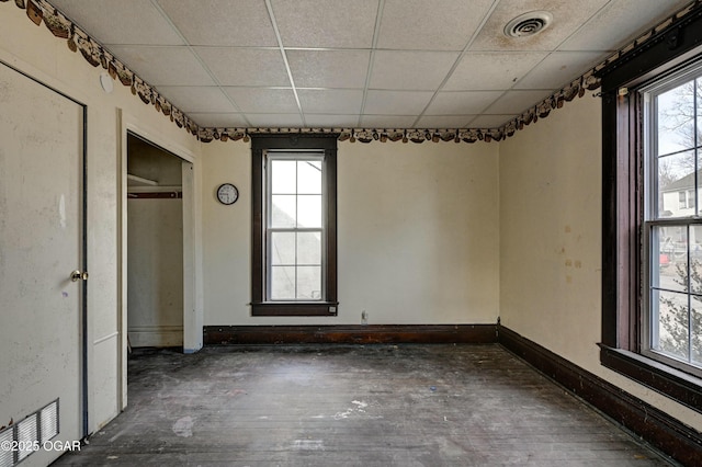 empty room with a paneled ceiling and dark hardwood / wood-style floors