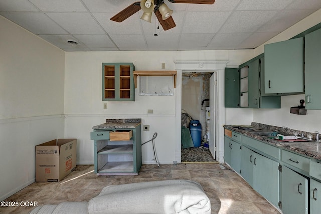 kitchen featuring a drop ceiling, sink, ceiling fan, and green cabinets