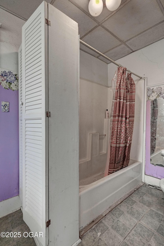 bathroom featuring a drop ceiling and shower / bath combination with curtain