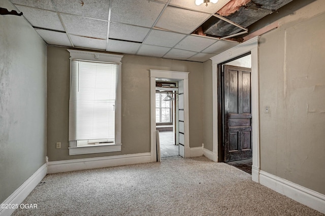 carpeted empty room featuring a paneled ceiling