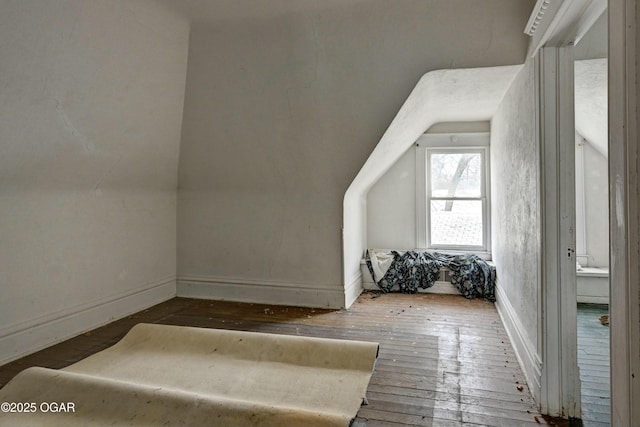 bonus room with dark hardwood / wood-style flooring and vaulted ceiling