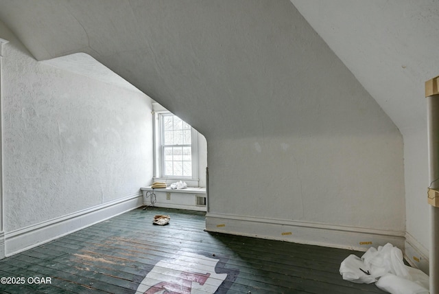 bonus room with vaulted ceiling and dark hardwood / wood-style floors