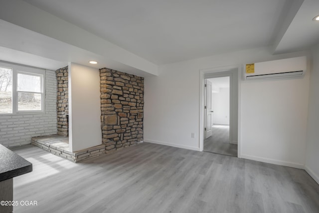 unfurnished living room featuring light hardwood / wood-style floors and a wall mounted AC