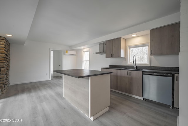 kitchen with sink, a center island, light wood-type flooring, an AC wall unit, and stainless steel dishwasher