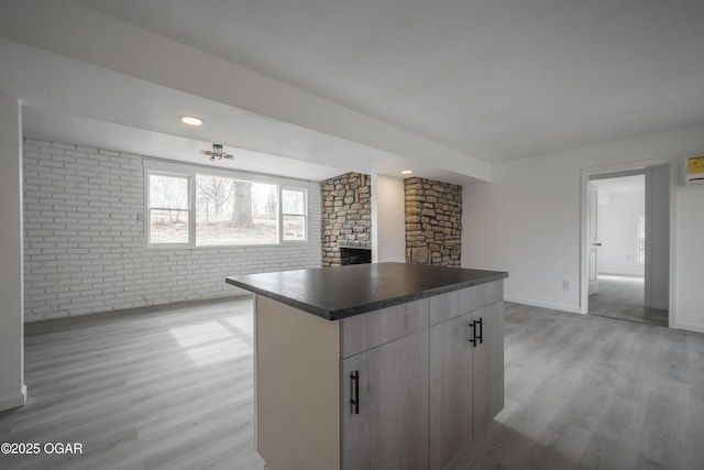 kitchen featuring brick wall, light hardwood / wood-style floors, and a kitchen island