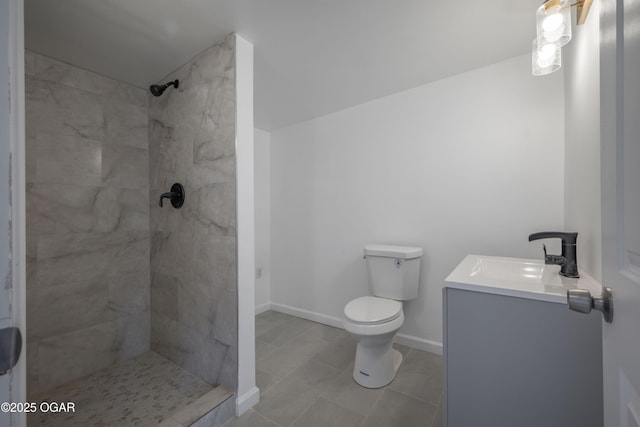 bathroom with vanity, a tile shower, tile patterned floors, and toilet