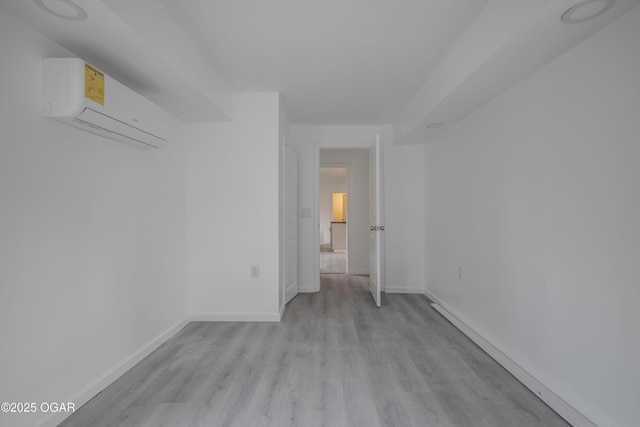 spare room featuring light hardwood / wood-style flooring and an AC wall unit