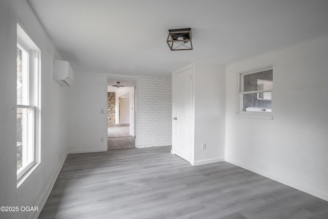 empty room with a wall mounted AC and light wood-type flooring