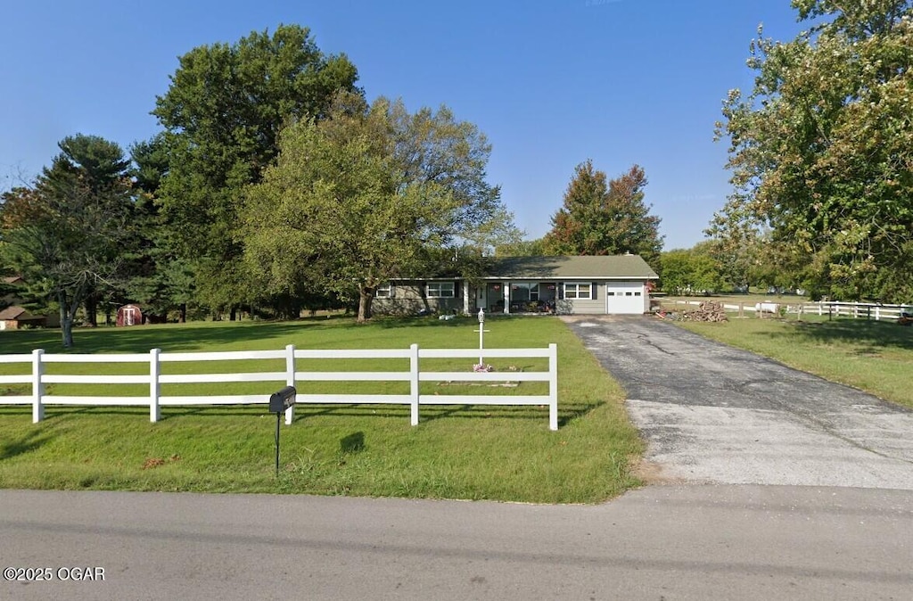 view of front facade featuring a garage, a front yard, and a rural view