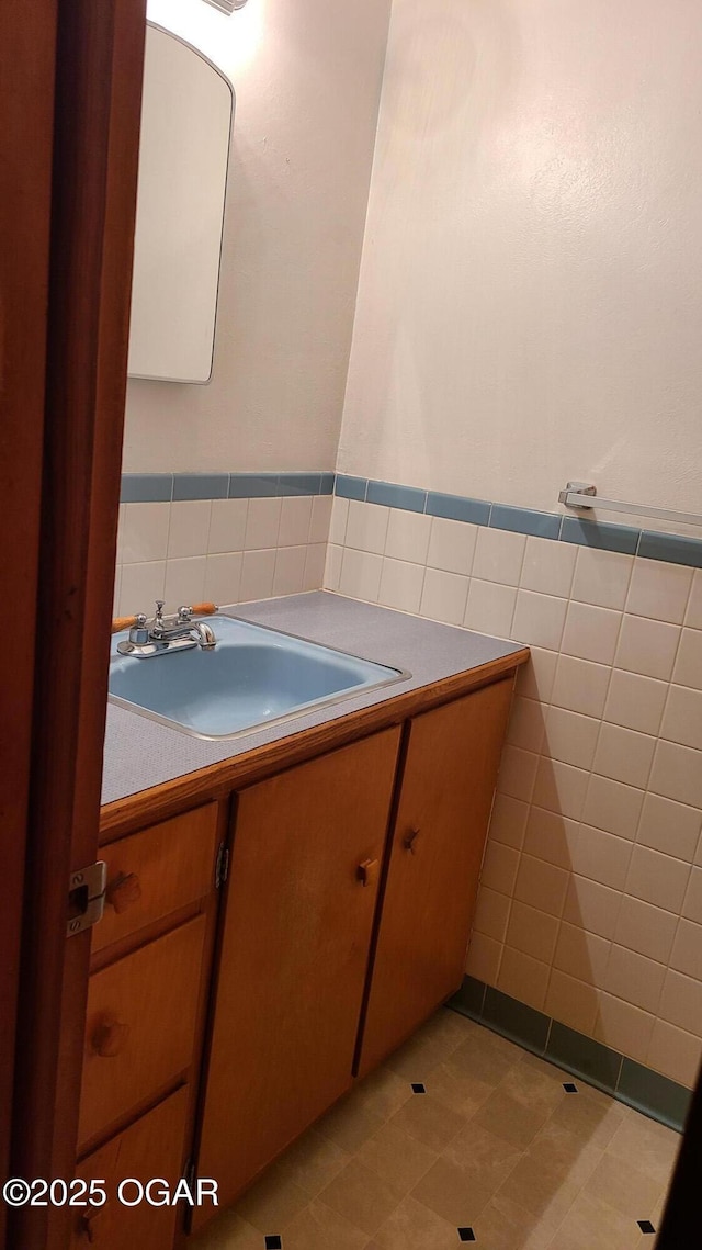 bathroom with vanity and tile walls