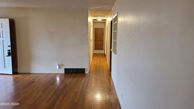 empty room with hardwood / wood-style flooring and a textured ceiling