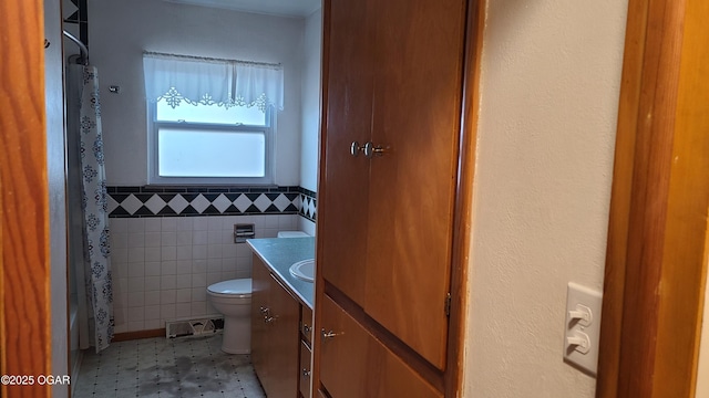 bathroom with vanity, tile walls, and toilet