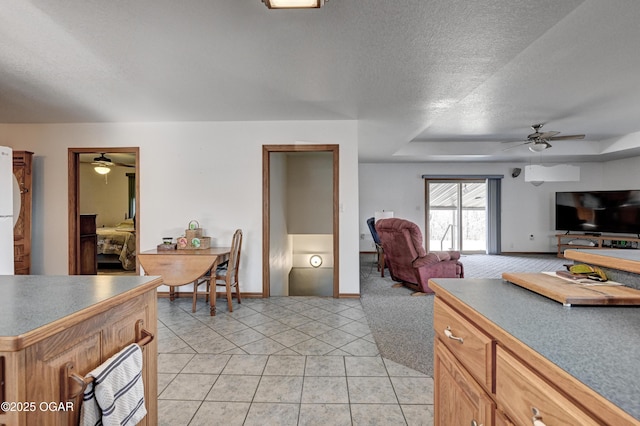 kitchen featuring light tile patterned flooring, ceiling fan, and a textured ceiling