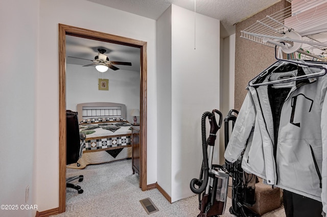 spacious closet with ceiling fan and light carpet