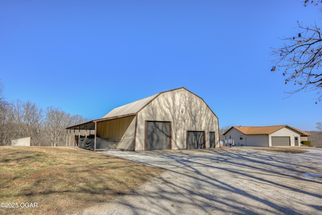 view of outbuilding with a carport and a garage