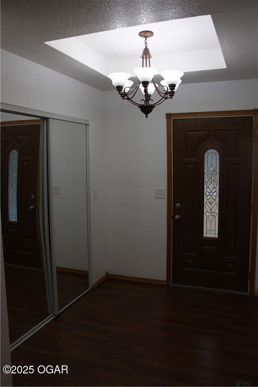 entrance foyer featuring dark hardwood / wood-style floors, a chandelier, and a textured ceiling