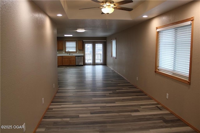 hall with a raised ceiling and dark hardwood / wood-style floors