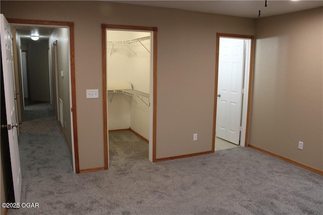 unfurnished bedroom featuring light carpet, a spacious closet, and a closet