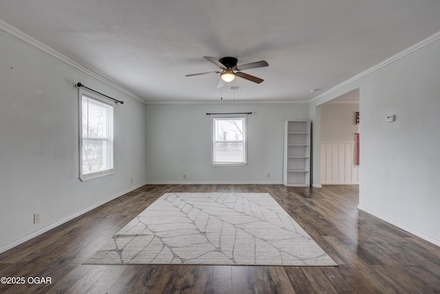 spare room with dark wood-type flooring, crown molding, baseboards, and ceiling fan