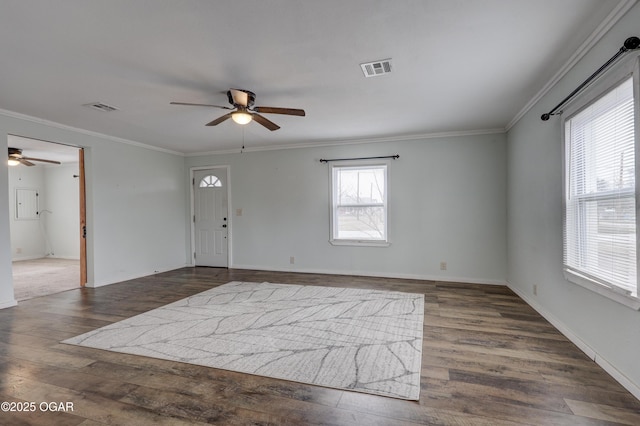 foyer entrance with baseboards, dark wood-type flooring, visible vents, and crown molding