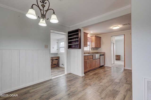 kitchen featuring stainless steel dishwasher, brown cabinetry, visible vents, and crown molding