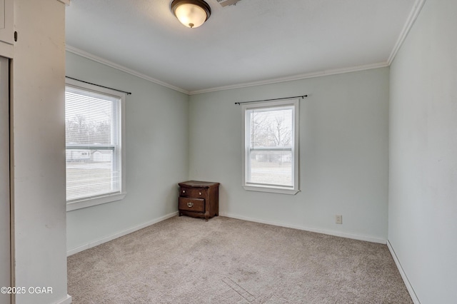 carpeted spare room with baseboards and ornamental molding