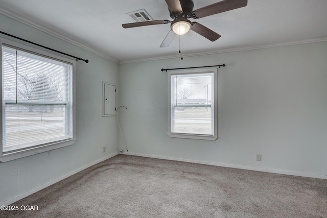 carpeted empty room featuring a ceiling fan, visible vents, crown molding, and baseboards