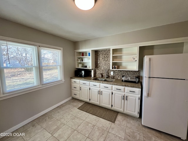 kitchen featuring sink, white cabinets, backsplash, white fridge, and light tile patterned floors