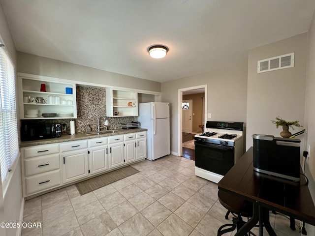 kitchen with light tile patterned flooring, sink, white cabinets, decorative backsplash, and white appliances