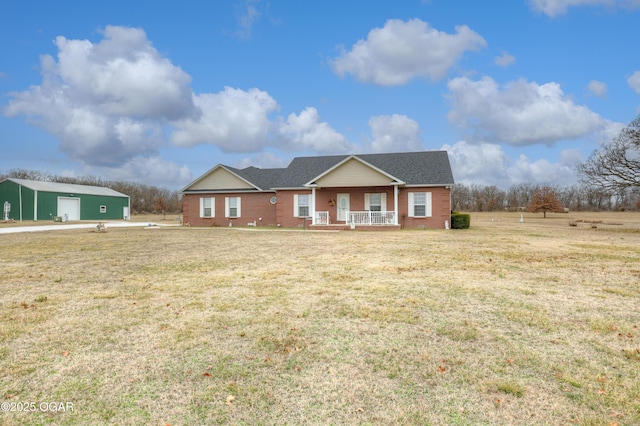 ranch-style house with a garage, an outdoor structure, covered porch, and a front lawn