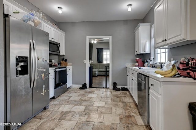 kitchen with a healthy amount of sunlight, appliances with stainless steel finishes, sink, and white cabinets