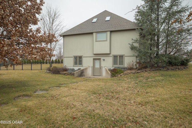 rear view of property featuring a lawn