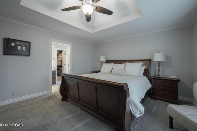 bedroom featuring a spacious closet, light carpet, a tray ceiling, a closet, and ceiling fan