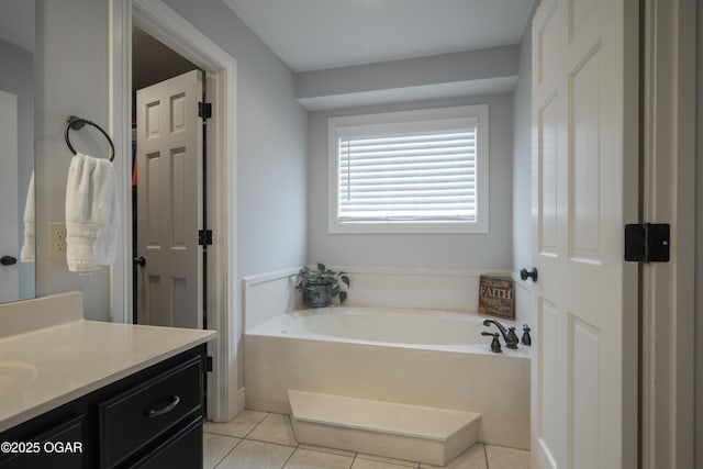 bathroom featuring a bathing tub, vanity, and tile patterned floors