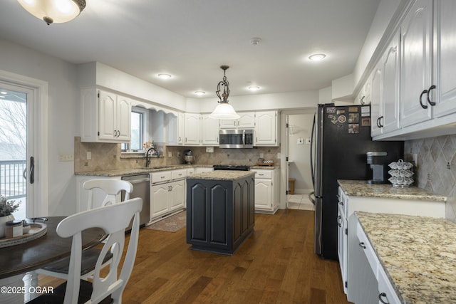 kitchen with appliances with stainless steel finishes, a kitchen island, and white cabinets