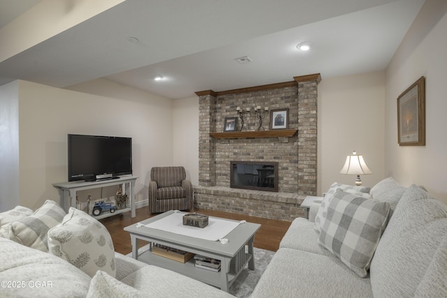 living room featuring hardwood / wood-style flooring and a brick fireplace