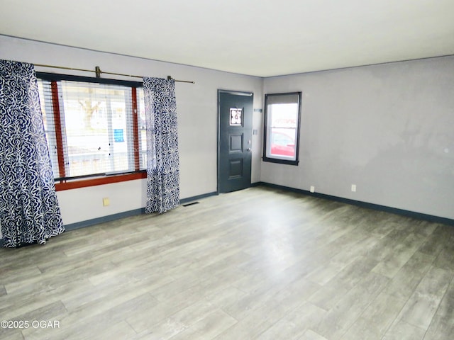 unfurnished room with light wood-type flooring