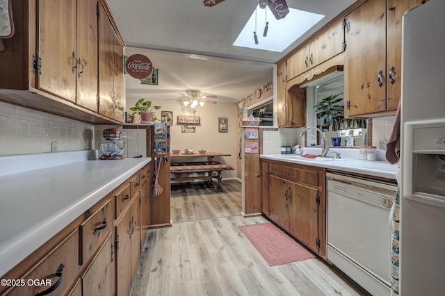 kitchen with sink, white dishwasher, refrigerator with ice dispenser, ceiling fan, and backsplash